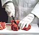 Picture of meat cutter using our cut resistant gloves.